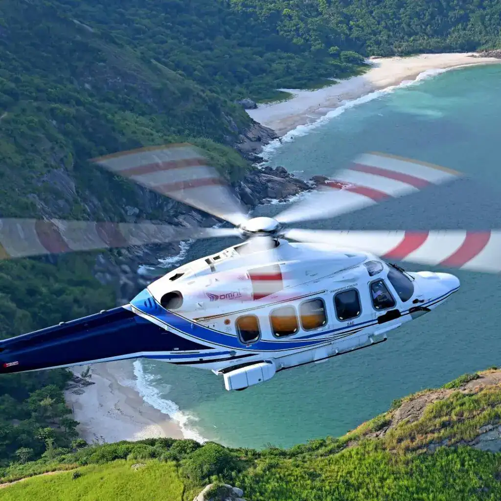 helicopter flying over mountain and beach