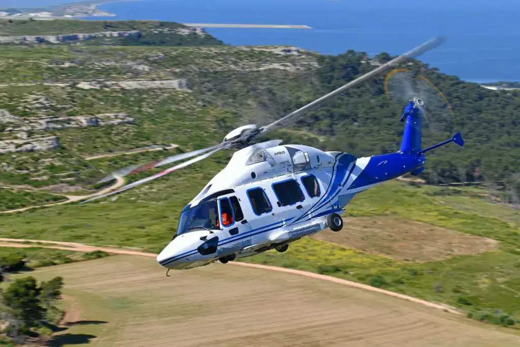 white and blue helicopter flying